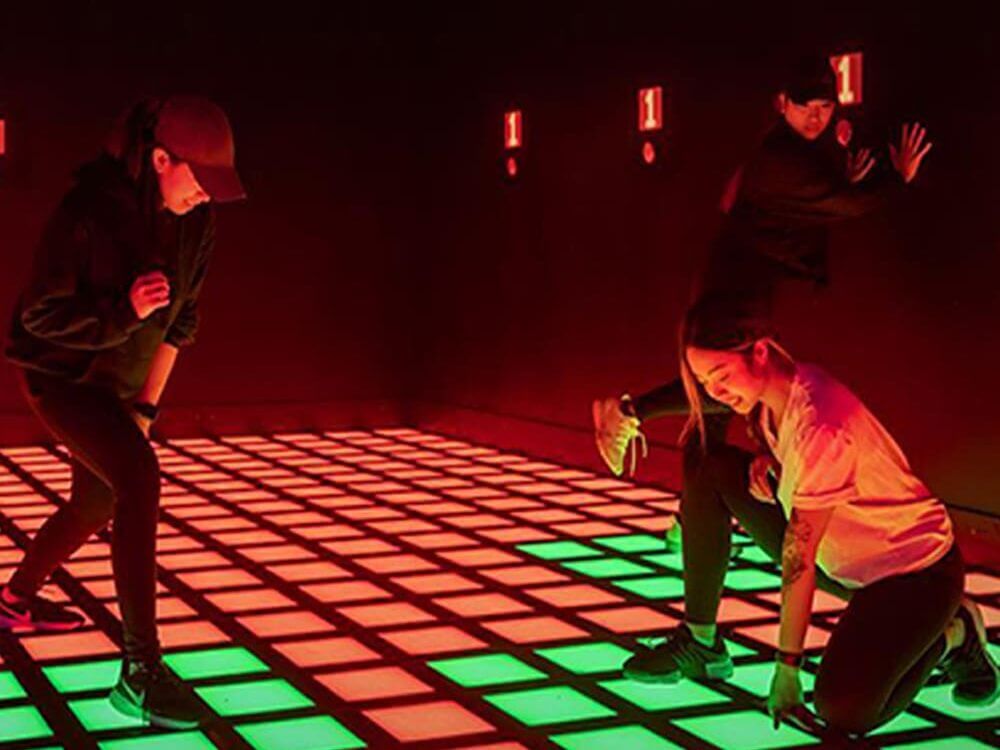 Players competing on the Axecessive Force Super Grid interactive LED floor
